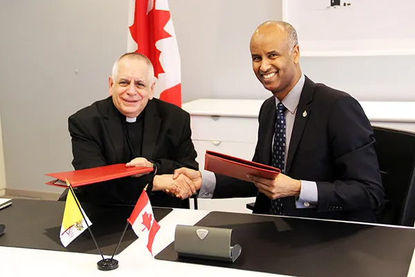 Monsignor Bob Vitillo e il ministro canadese per i rifugiati Ahmed Hussen siglano l'accordo / ICMC