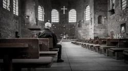 Un uomo in preghiera davanti ad una croce in una chiesa / pxhere - public domain