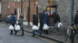 Senzatetto escono con i pacchi alimentari dal Capuchin Day Centre di Dublino / Broadsheet