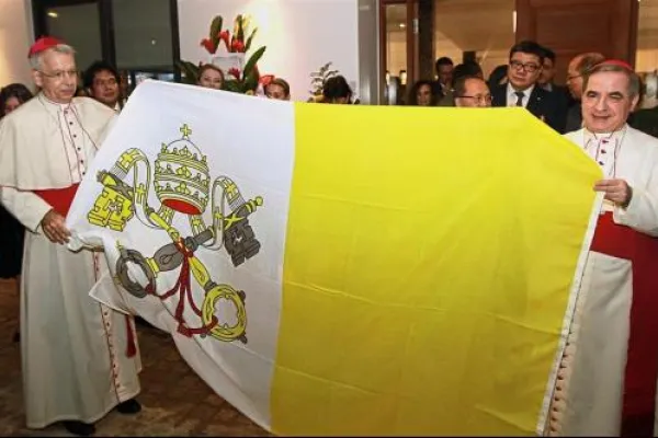 L'arcivescovo Angelo Becciu, sostituto della Segreteria di Stato vaticano, e l'arcivescovo Joseph Marino, nunzio apostolico in Malesia, mostrano la bandiera della Santa Sede all'inaugurazione della nunziatura di Kuala Lumpur / The Star - www.thestar.com.my