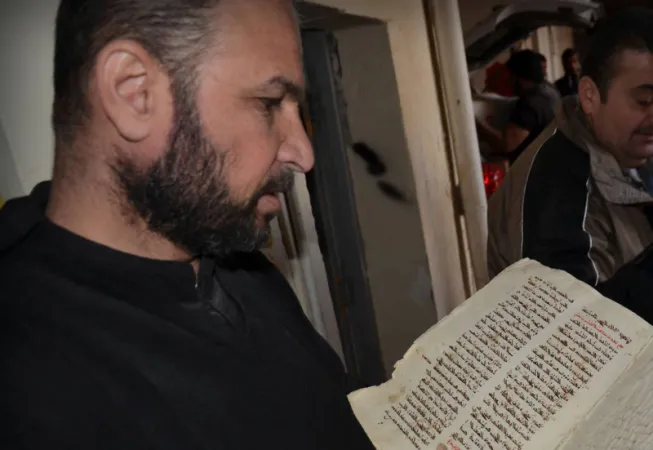 Mar Benham | Padre Joseph con i manoscritti recuperati a Mar Benham | www.ankawa.com