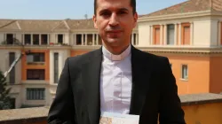 Padre Rebwar Basa, autore del libro su Padre Ragheed, posa con il libro nella sede italiana di Aiuto alla Chiesa che Soffre, Roma, 1 giugno 2017 / Mary Shovlain / ACI Group