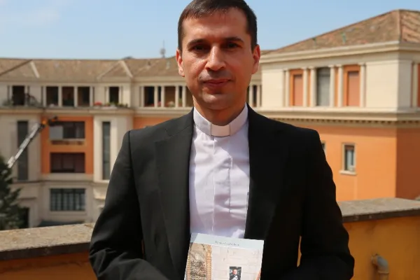 Padre Rebwar Basa, autore del libro su Padre Ragheed, posa con il libro nella sede italiana di Aiuto alla Chiesa che Soffre, Roma, 1 giugno 2017 / Mary Shovlain / ACI Group