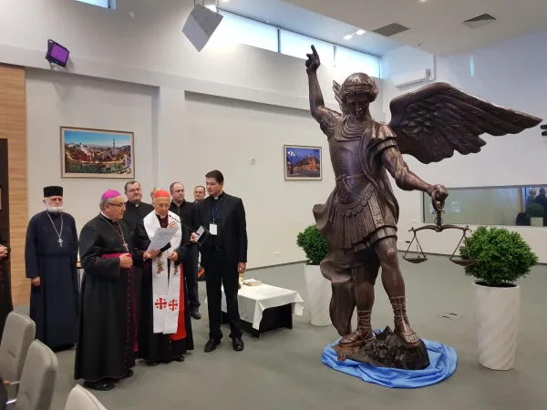 Plenaria CCEE a Minsk | Il Cardinale Angelo Bagnasco, presidente del CCEE, benedice la statua di San Michele all'inizio dei lavori  | Andrea Gagliarducci / ACI Stampa